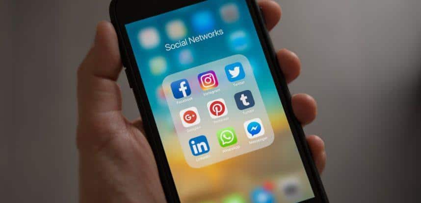 Person Holding Iphone Showing Social Networks Folder