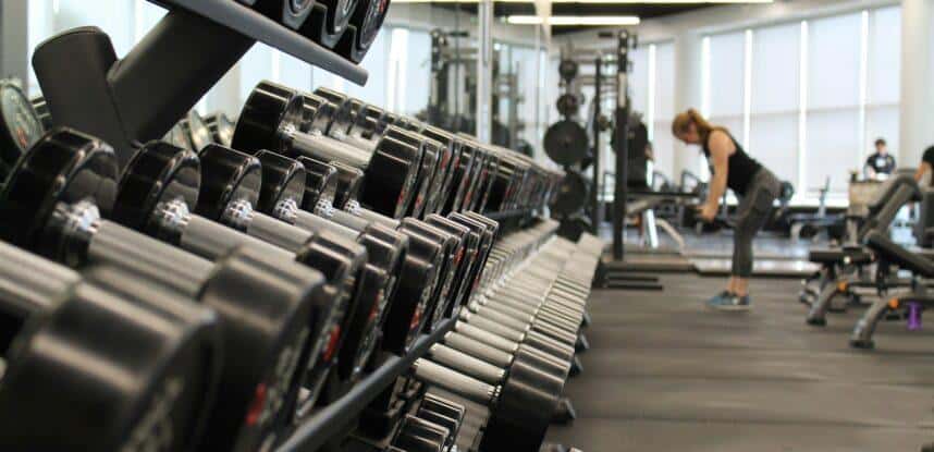 woman standing surrounded by exercise equipment
