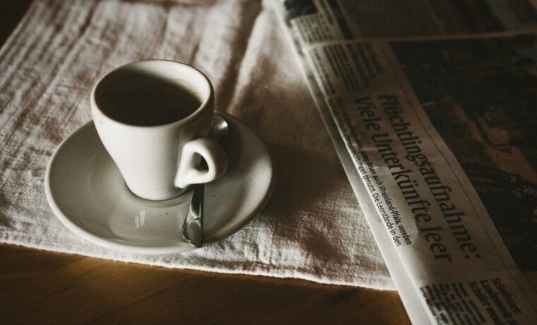 Periódico y taza de café sobre una mesa, la lectura diaria de la redacción de OMC 2015